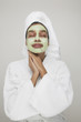 Woman wearing robe with beauty mask on face
