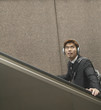 Man with headphones riding escalator