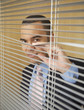 Businessman peering through blinds
