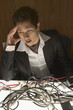 Businessman puzzling over a nest of wires