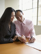 Couple holding hands while signing a document