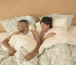High angle view of couple asleep in bed