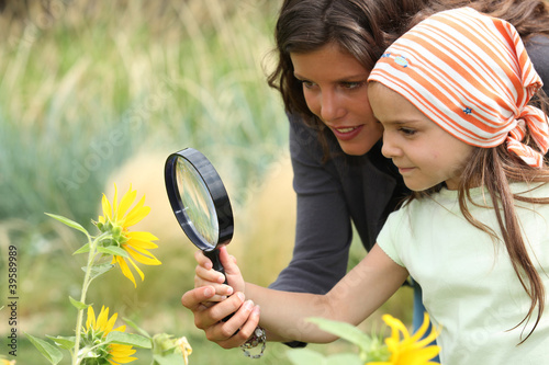 Photo: Mother and daughter looking at a flower with a magnifying glass Mother and daughter looking at a flower with a magnifying glass