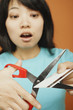Asian woman cutting up credit card
