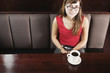 Woman in booth with cup of coffee