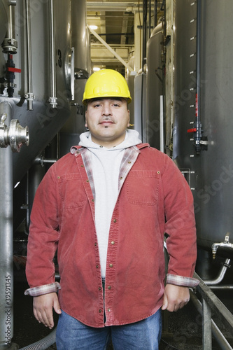 Photo: Man standing in front of holding tanks Man standing in front of holding tanks