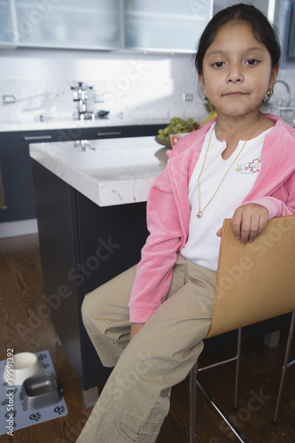 Photo: Girl sitting in kitchen at home Girl sitting in kitchen at home