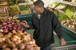 African American man choosing vegetables in supermarket