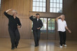Three seniors practicing Tai Chi indoors