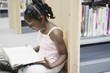 Girl reading book in library
