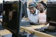 Man and girl posing by computers