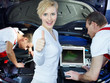 Photo: Customer shows thumb up in front of motor mechanics in a garage Customer shows thumb up in front of motor mechanics in a garage