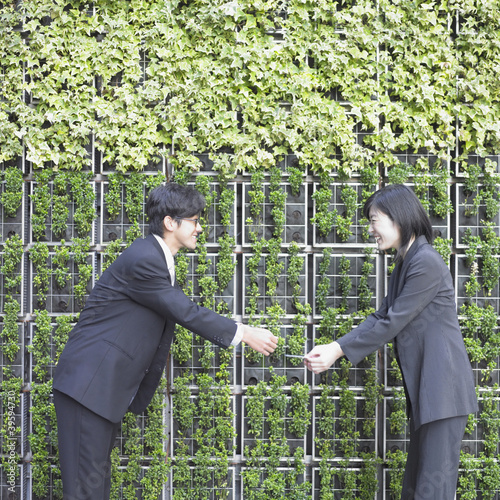 Photo: Businessman and businesswoman passing credit card Businessman and businesswoman passing credit card