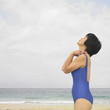Woman in bathing suit meditating at beach