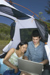 Couple in tent with laptop