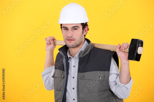 Photo: A man carrying a sledgehammer. A man carrying a sledgehammer.