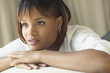 Young woman resting her chin on hands while thinking
