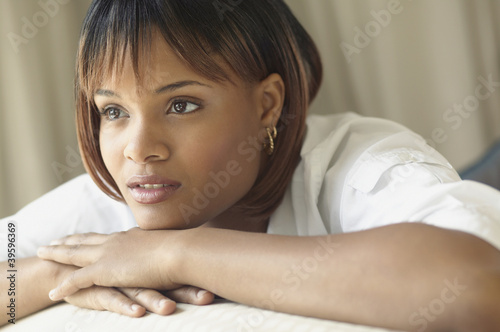 Photo: Young woman resting her chin on hands while thinking Young woman resting her chin on hands while thinking