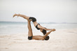 Couple practicing gymnastics on the beach