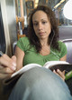 Teenager doing homework on subway