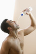 Profile of man pouring water in his mouth
