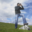Man taking a picture with one foot on a rock