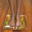 Young woman standing on a wooden tray of water