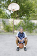 Young boy sitting on basketball