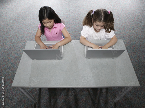Photo: Two girls in classroom with laptops Two girls in classroom with laptops