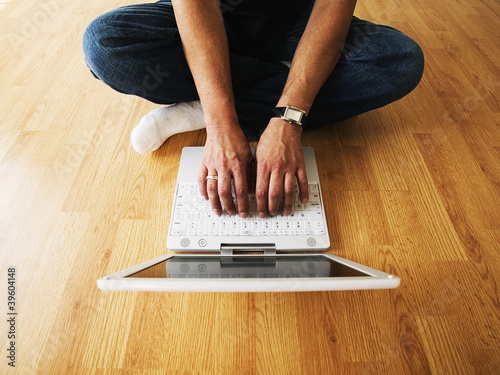 Photo: Low section of man typing on laptop Low section of man typing on laptop