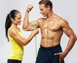 Woman measuring athletic's man biceps.