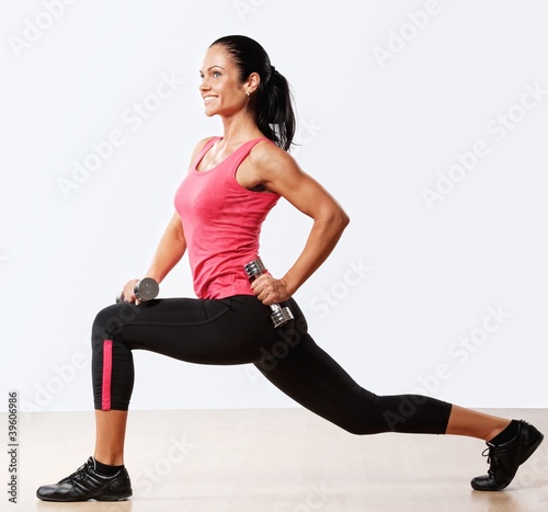 Photo: Beautiful woman doing fitness exercise with dumbbellls. Beautiful woman doing fitness exercise with dumbbellls.