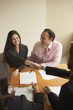 Couple shaking hands with businessman