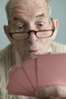 Elderly man holding a winning hand
