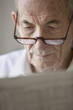 Elderly man reading newspaper