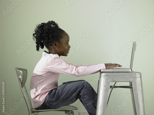 Photo: Young girl using a laptop Young girl using a laptop