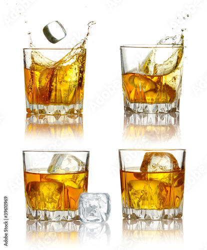 Photo: Set of scotch whiskey glasses with splash and ice isolated Set of scotch whiskey glasses with splash and ice isolated