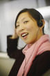 Asian woman smiling and wearing headphones