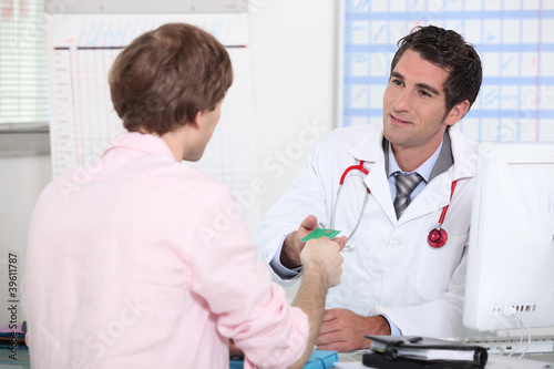Photo: Patient handing card to doctor Patient handing card to doctor