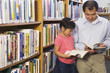 Father and daughter looking at library books