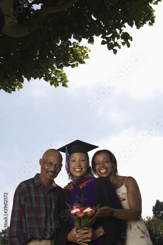 Photo: Female graduate with parents Female graduate with parents