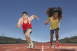 Two male track participants race