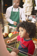 Young African American boy in shopping cart at supermarket checkout