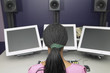 African American woman sitting at desk with multiple computer monitors