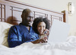 Couple shopping online in bed