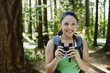 Woman with binoculars in forest