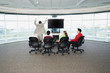 Rear view of group sitting around big screen TV with one man cheering