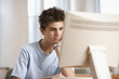 Teenage boy sitting in front of computer