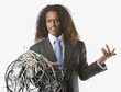 Businessman holding tangled computer cords