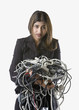 Businesswoman holding tangled computer cords